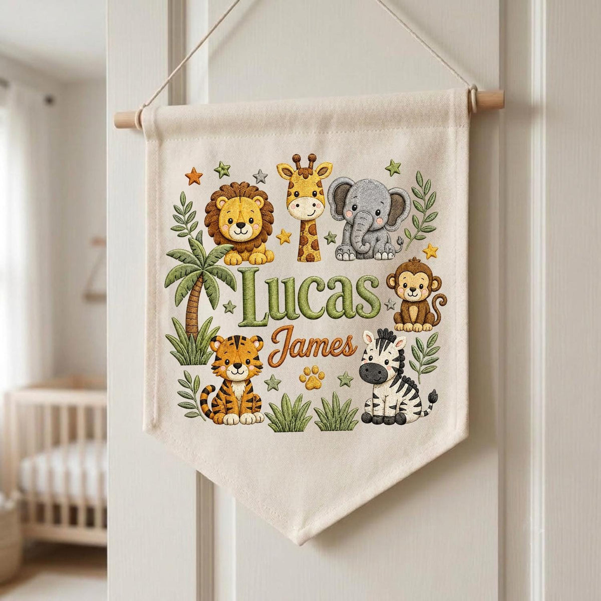 May include: A cream-colored fabric wall hanging banner featuring a colorful illustration of a lion, giraffe, elephant, monkey, tiger, and zebra. The text Lucas James is printed in the center in green and orange script surrounded by small stars.