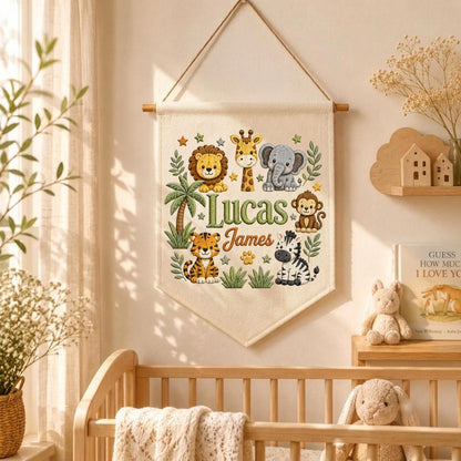May include: A cream-colored fabric wall hanging banner featuring a colorful illustration of a lion, giraffe, elephant, monkey, tiger, and zebra. The text "Lucas James" is printed in the center in green and brown script and block lettering.