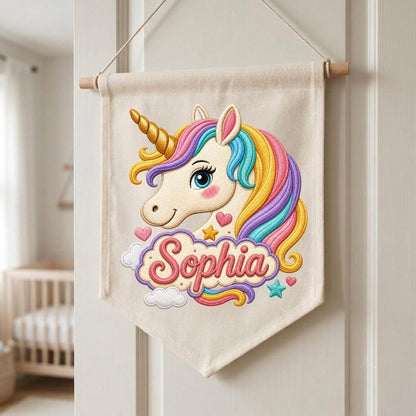 May include: A cream-colored fabric wall banner featuring an embroidered unicorn head with a gold horn and a multi-colored mane in shades of pink, yellow, and blue. Below the unicorn, the name Sophia is embroidered in pink script lettering.