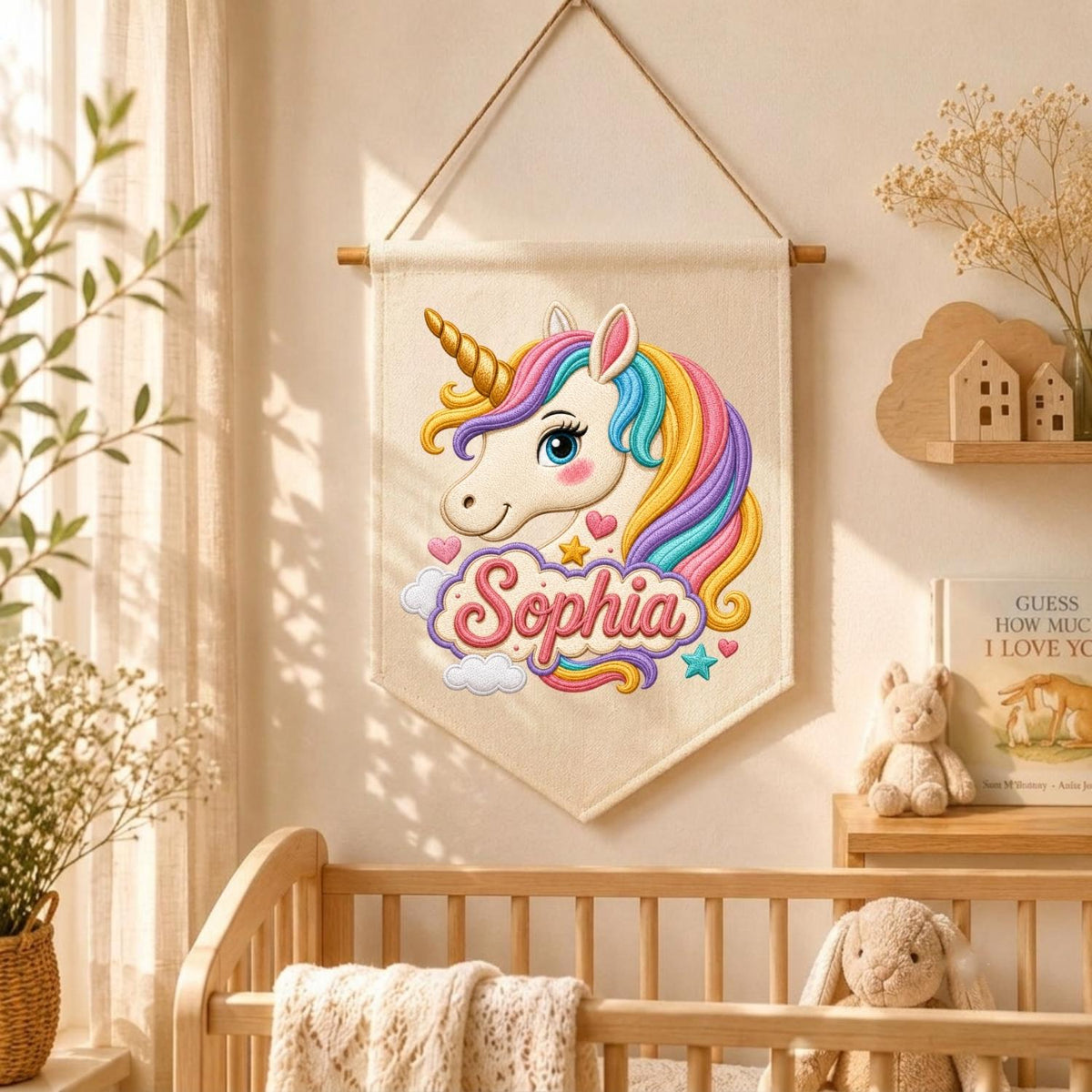 May include: A cream-colored fabric wall hanging featuring a cartoon unicorn head with a multi-colored mane in shades of pink, yellow, and blue. The name Sophia is printed in pink cursive script below the unicorn, surrounded by small hearts, stars, and clouds.