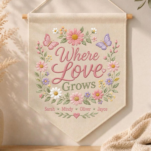May include: A beige fabric wall banner featuring embroidered floral wreaths in pink, purple, and white with two butterflies. The text reads Where Love Grows, followed by the names Sarah, Mindy, Oliver, and Jayce, separated by small hearts.