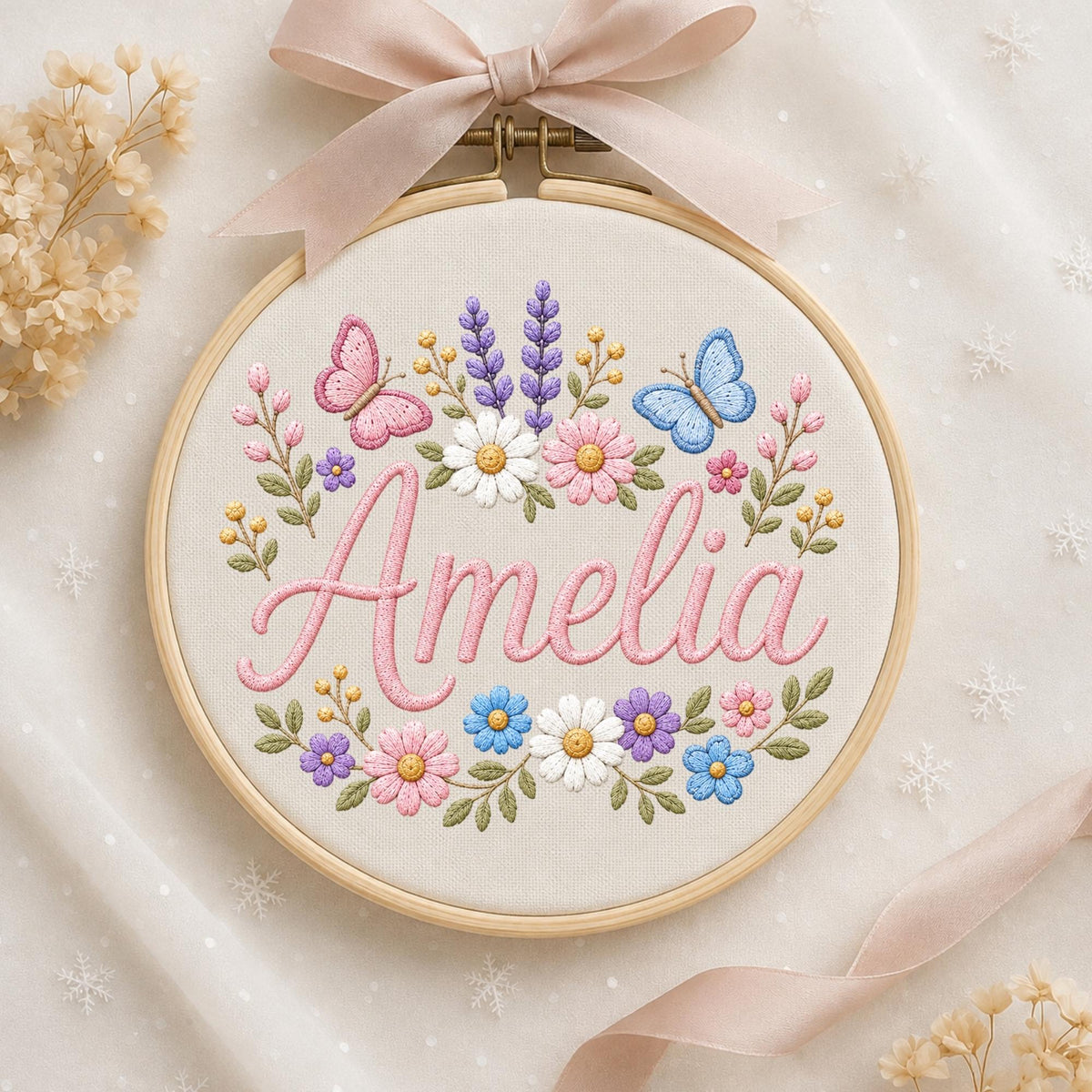 May include: A circular wooden embroidery hoop containing cream-colored fabric with the name Amelia stitched in pink cursive thread. The design features embroidered pink and blue butterflies, purple lavender sprigs, and various colorful floral motifs.