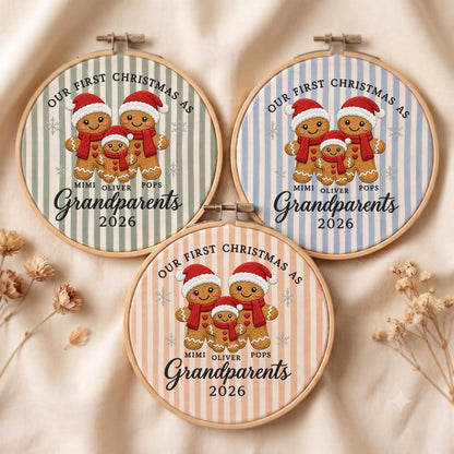 May include: Three circular embroidery hoops featuring fabric with vertical stripes in sage green, light blue, and peach. Each hoop displays three gingerbread figures wearing red hats and scarves, with the text "OUR FIRST CHRISTMAS AS GRANDPARENTS 2026" and the names "MIMI", "OLIVER", and "POPS".