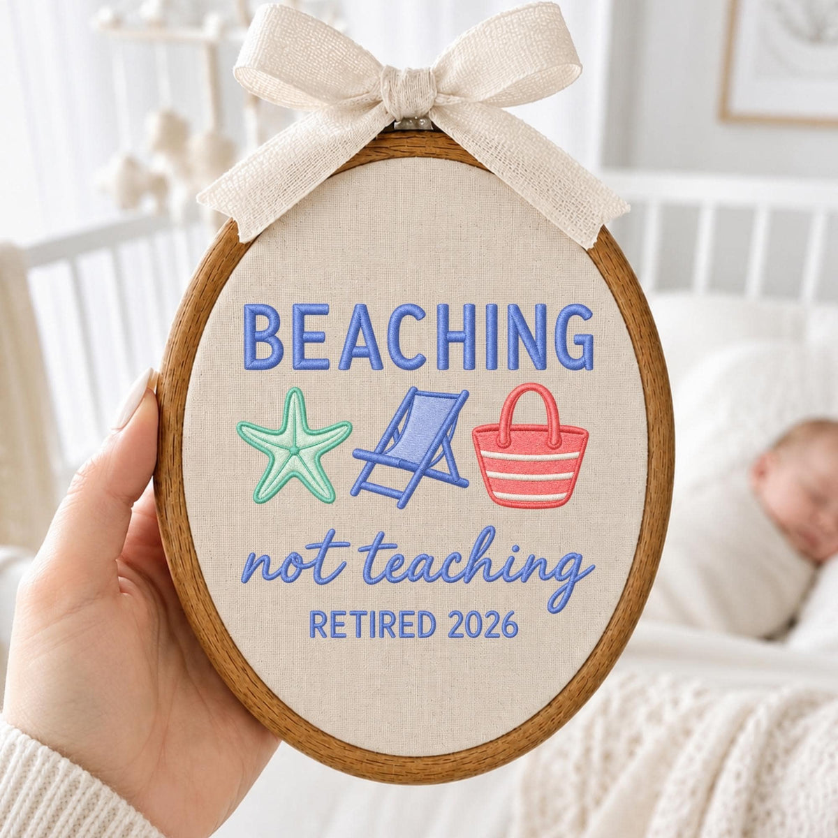 May include: An oval wooden embroidery hoop containing beige fabric with the embroidered text BEACHING not teaching RETIRED 2026. The design includes a teal starfish, a blue beach chair, and a red and white striped tote bag, topped with a beige bow.