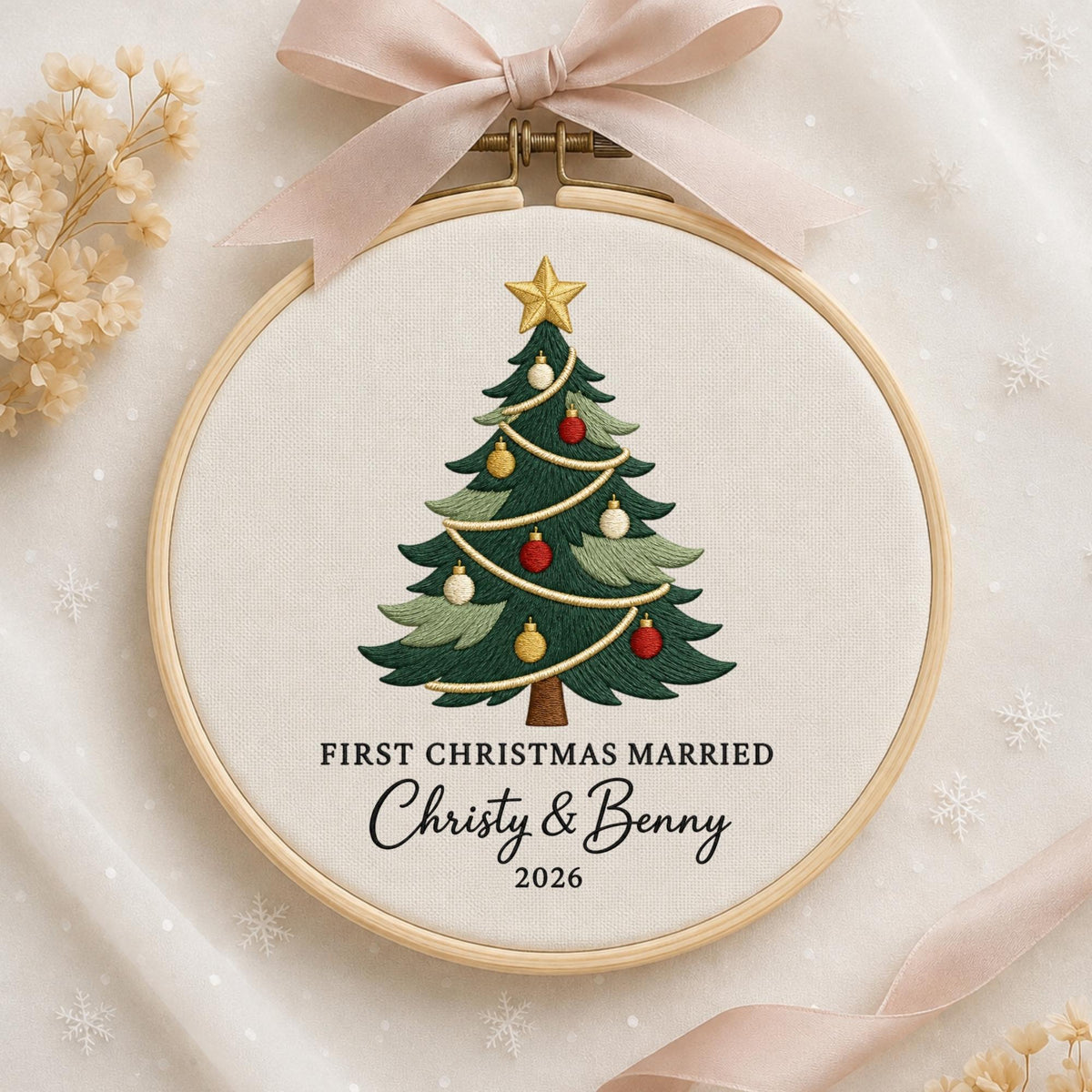 May include: A round wooden embroidery hoop containing white fabric with a stitched green Christmas tree decorated with red, gold, and white ornaments and a gold star. The text reads FIRST CHRISTMAS MARRIED, Christy &amp; Benny, 2026.