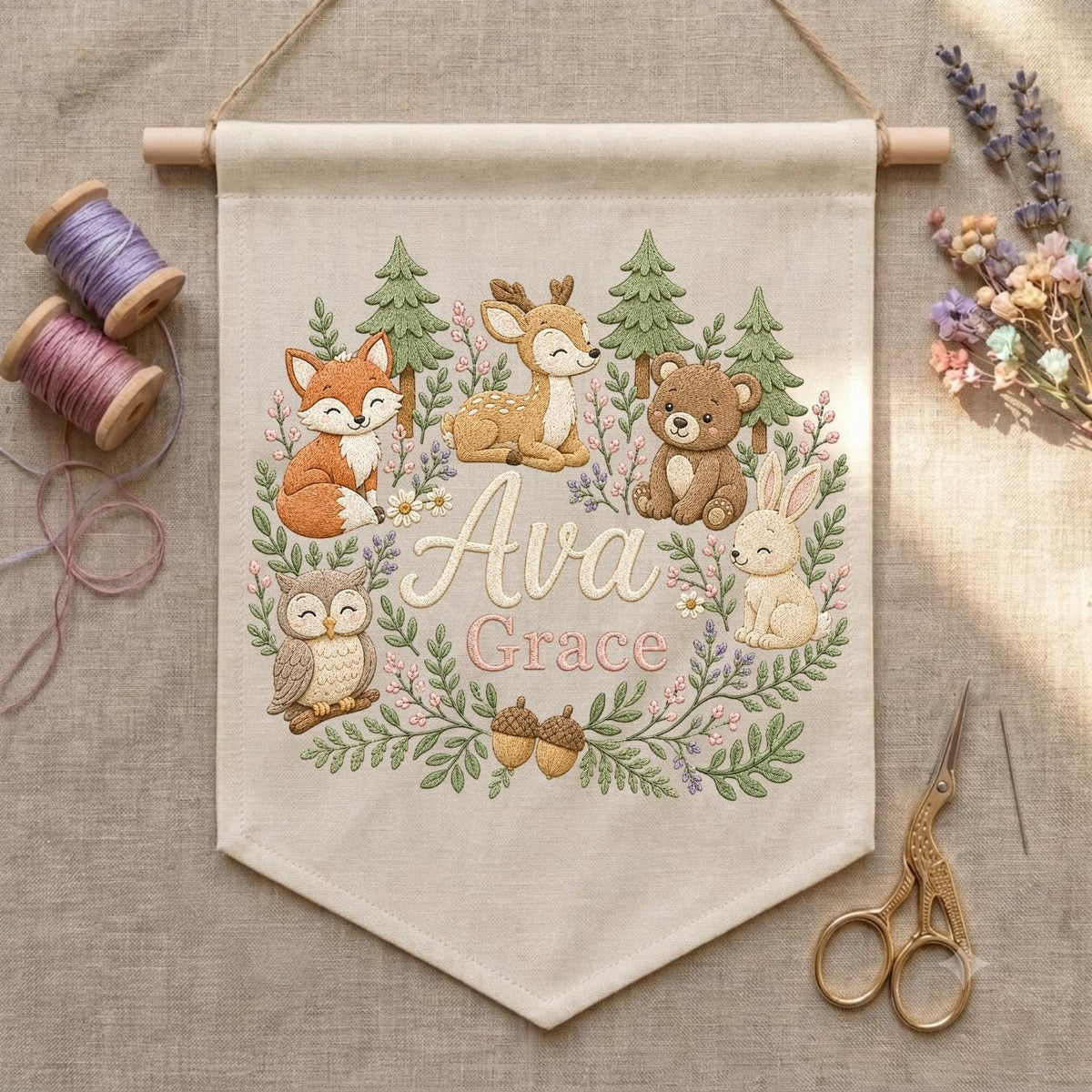 May include: A beige fabric wall hanging featuring an embroidered woodland scene with a fox, deer, bear, owl, and rabbit. The center displays the name Ava Grace in cursive script, surrounded by green pine trees, floral vines, and two acorns.