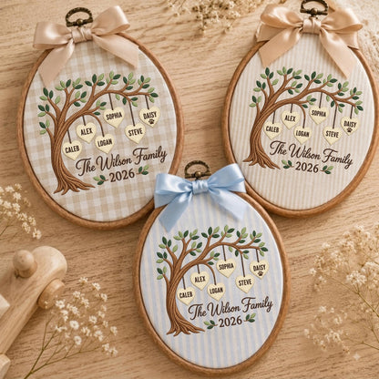 May include: Three oval embroidery hoops featuring fabric backgrounds with a brown embroidered tree. Each tree has hanging heart-shaped tags with names: Caleb, Alex, Logan, Sophia, Steve, and Daisy. Text reads The Wilson Family 2026.