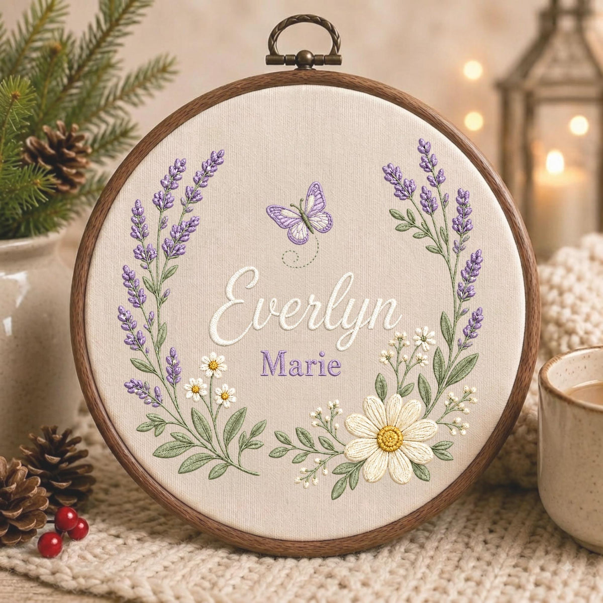May include: A circular wooden embroidery hoop containing beige fabric with a hand-stitched design. The embroidery features a lavender and daisy wreath surrounding the names Everlyn Marie in white and purple script, with a small purple butterfly.