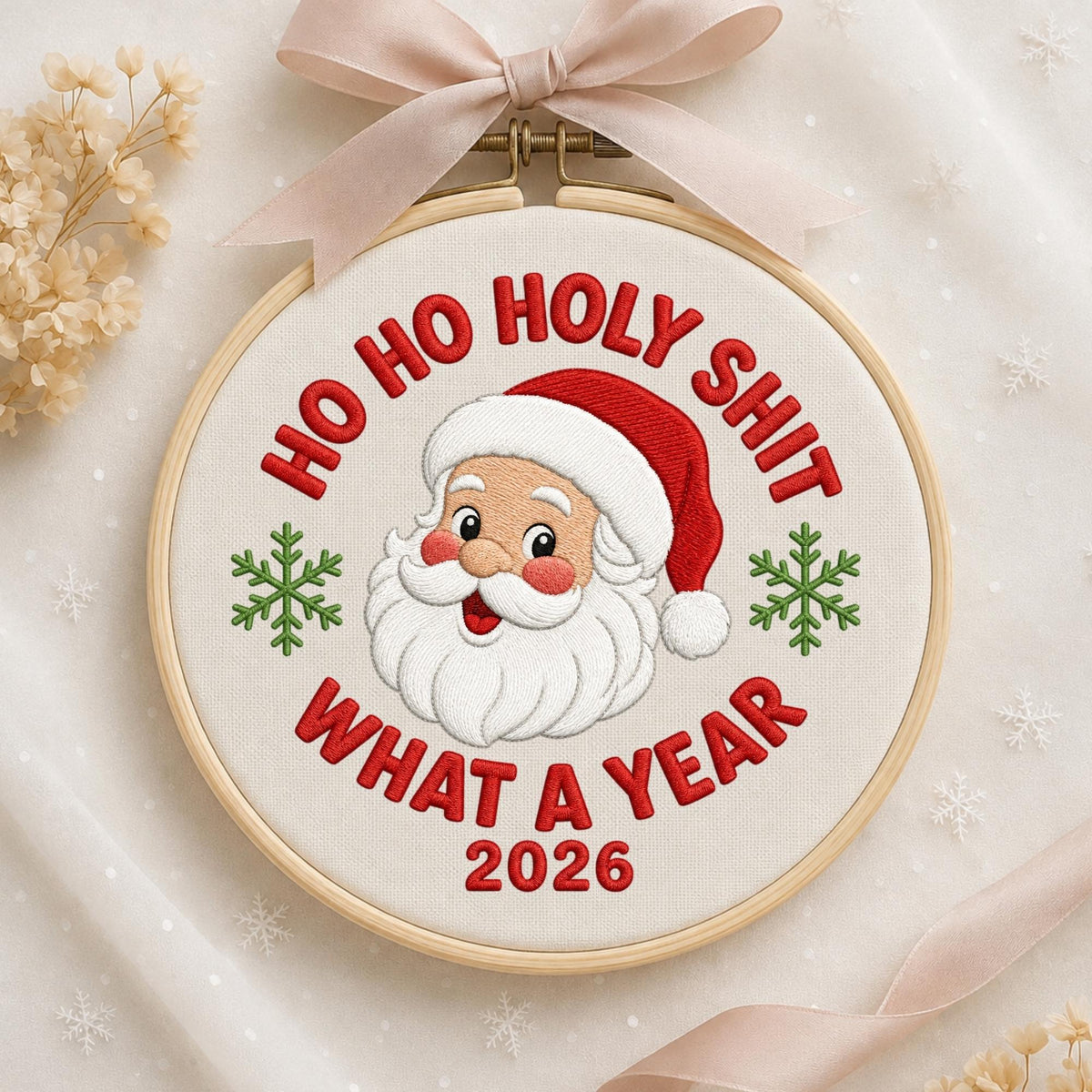May include: A circular wooden embroidery hoop containing white fabric with a machine-embroidered Santa Claus face, two green snowflakes, and the red text HO HO HOLY SHIT WHAT A YEAR 2026. A light beige ribbon is tied in a bow at the top.
