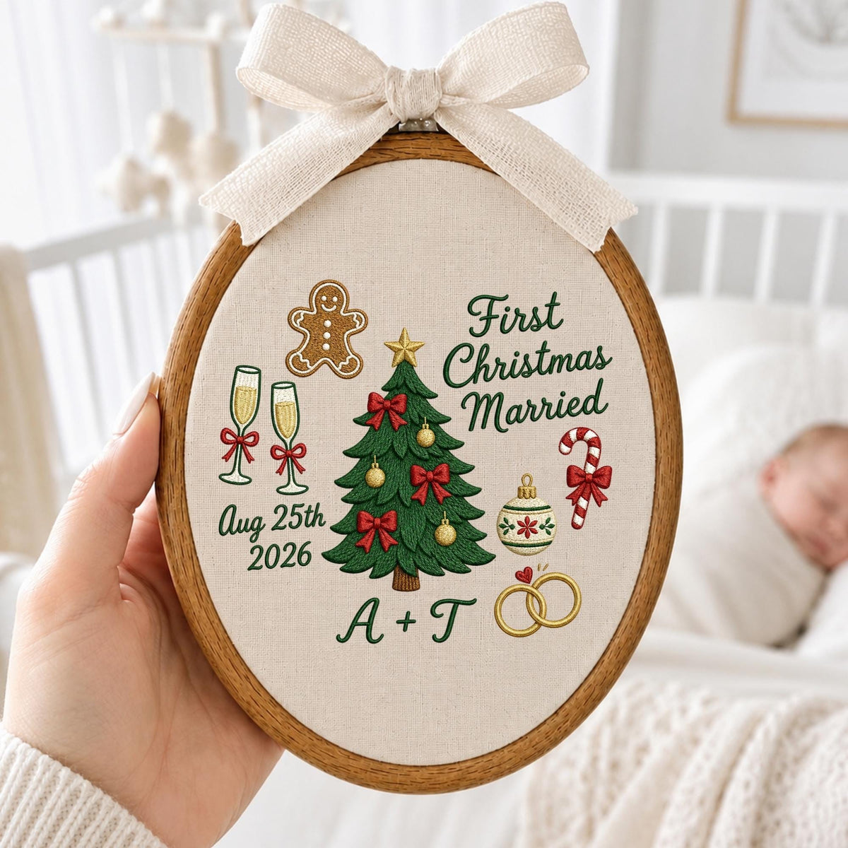 May include: An oval wooden embroidery hoop containing cream fabric with embroidered Christmas motifs, including a tree, gingerbread man, champagne flutes, candy cane, and rings. Text reads First Christmas Married, Aug 25th 2026, and A + T. A beige ribbon bow is attached to the top.