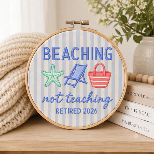 May include: A circular embroidery hoop featuring light blue and white vertical stripes. The text reads BEACHING not teaching RETIRED 2026. Embroidered icons include a mint green starfish, a blue beach chair, and a red and white striped beach bag.