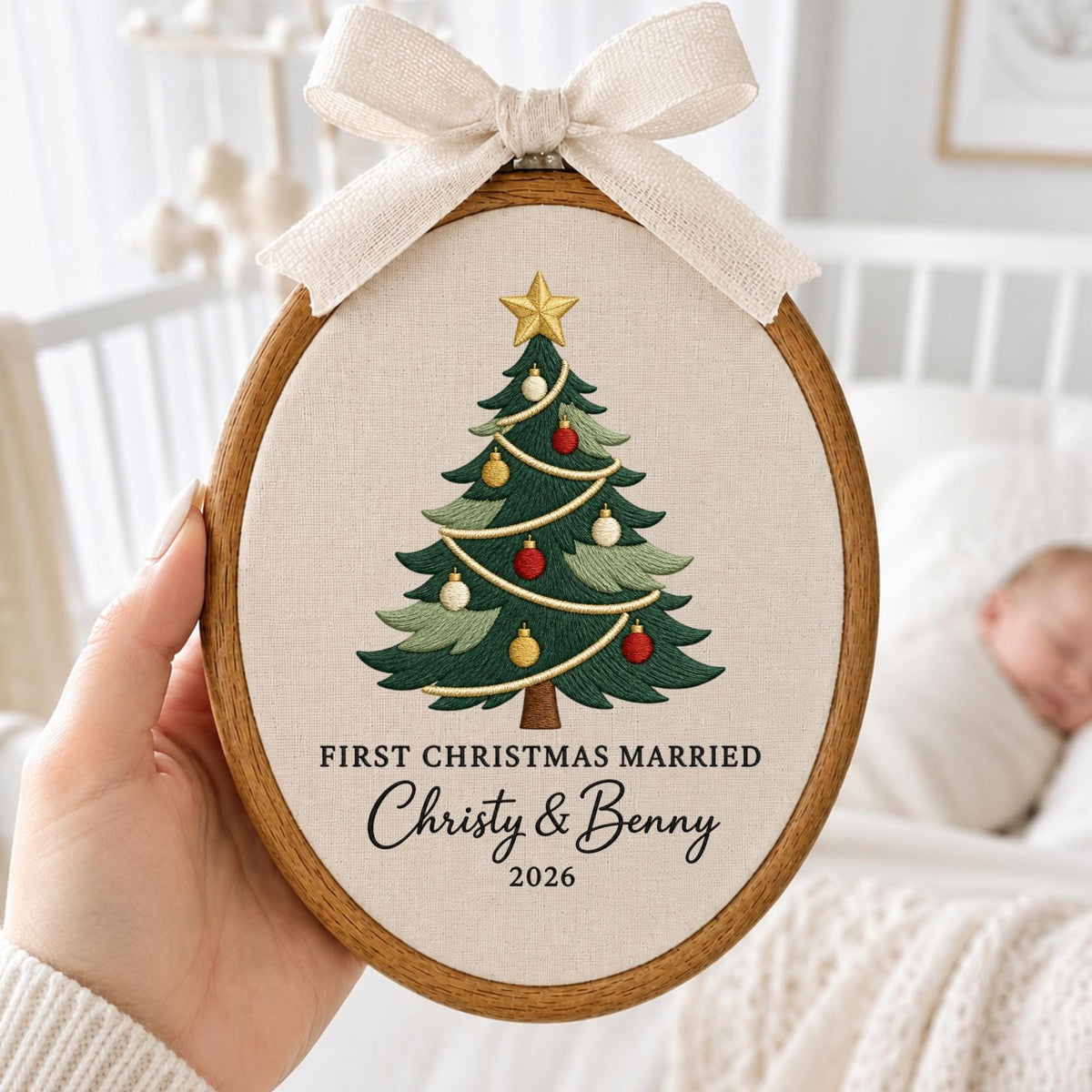 May include: An oval wooden embroidery hoop containing cream fabric with an embroidered green Christmas tree topped with a gold star and decorated with red and gold ornaments. The text reads FIRST CHRISTMAS MARRIED Christy &amp; Benny 2026.