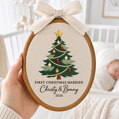 May include: An oval wooden embroidery hoop containing cream fabric with an embroidered green Christmas tree topped with a gold star and decorated with red and gold ornaments. The text reads FIRST CHRISTMAS MARRIED Christy &amp; Benny 2026.