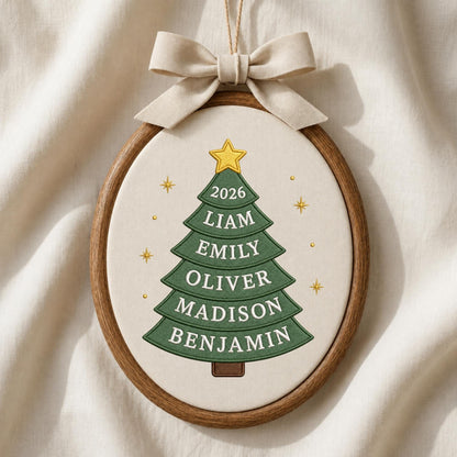 May include: An oval embroidery hoop ornament featuring a green fabric Christmas tree with a yellow star on top. The tree displays the year 2026 and the names Liam, Emily, Oliver, Madison, and Benjamin. A beige fabric bow is attached to the top.