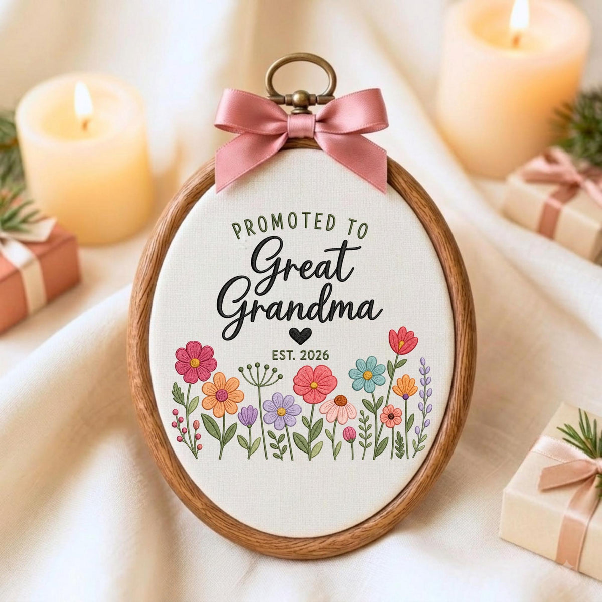 May include: An oval wooden embroidery hoop containing white fabric with the text "PROMOTED TO Great Grandma" and "EST. 2026" in black lettering, accented by a small black heart and a colorful floral illustration. A dusty pink satin bow is attached.