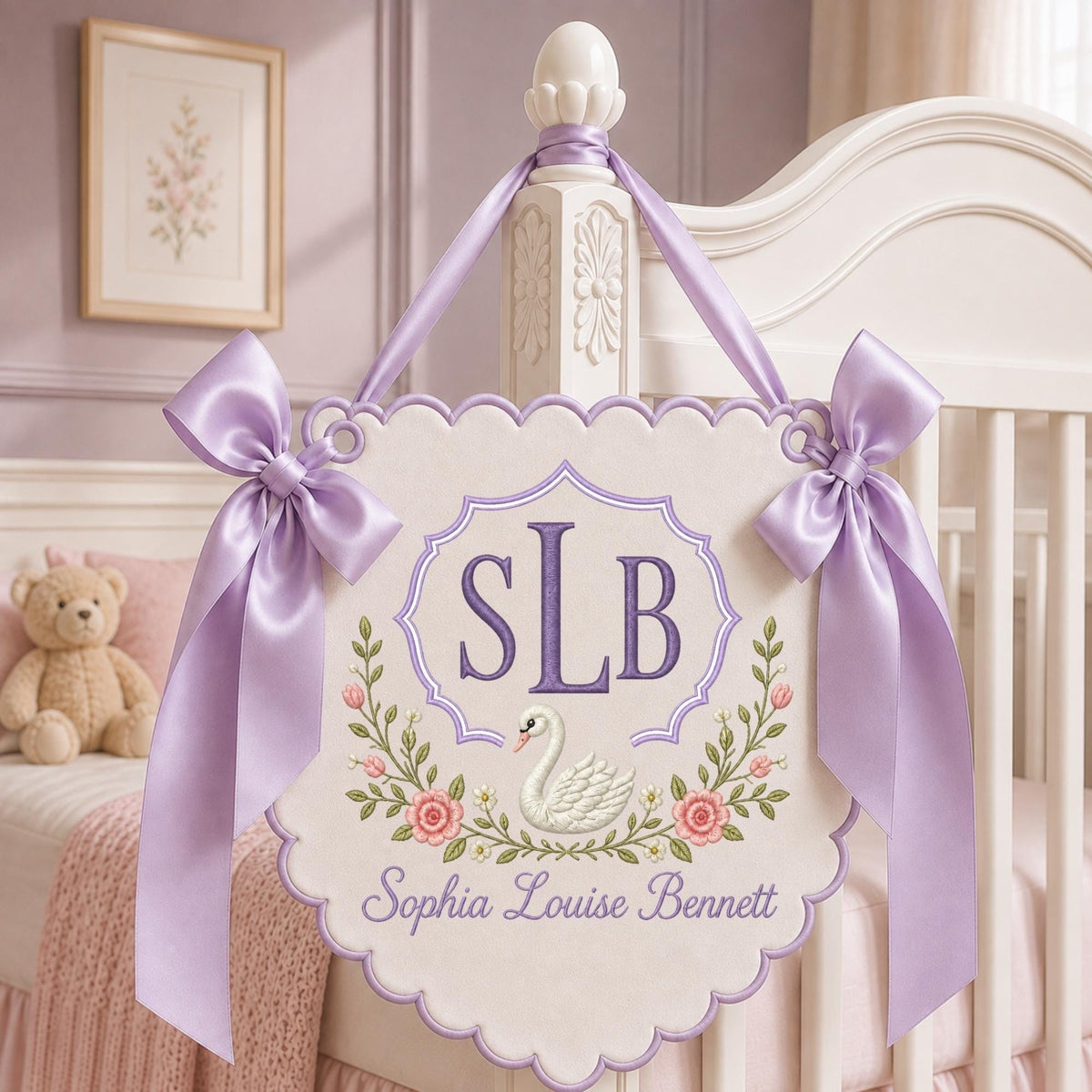 May include: A cream-colored scalloped wall hanging featuring a purple embroidered monogram SLB, a white swan illustration, and floral accents. The sign is suspended by a lavender satin ribbon with large bows on each side and includes the name Sophia Louise Bennett embroidered in purple script at the bottom.