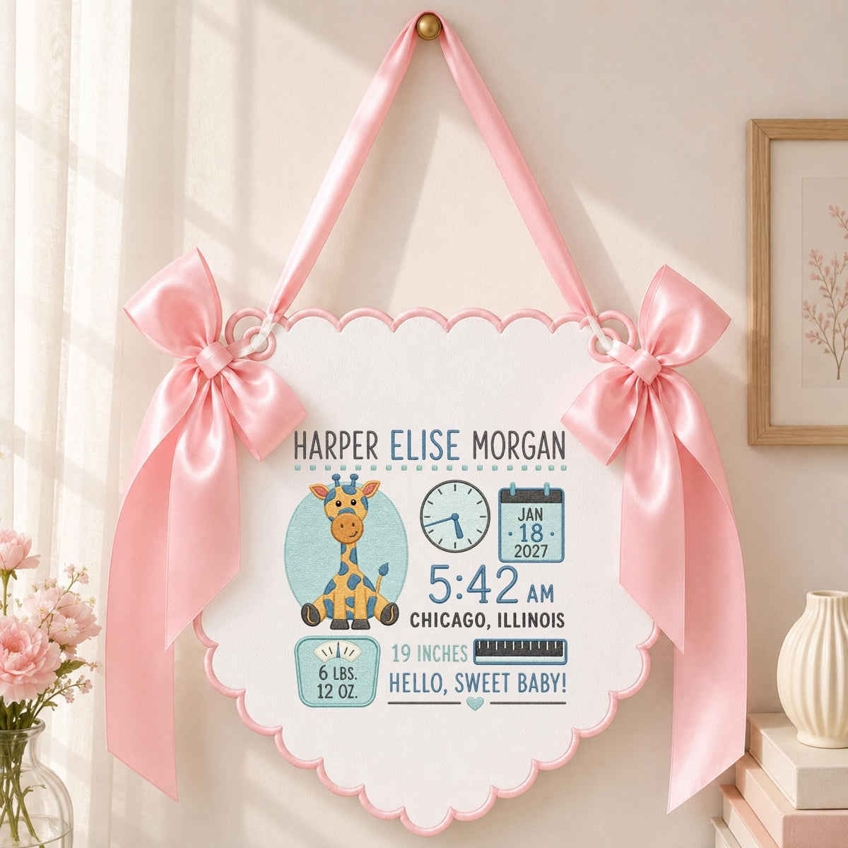 May include: A white scalloped wall hanging featuring a cartoon giraffe, a clock showing 5:42, a calendar marked Jan 18 2027, and text reading Harper Elise Morgan, Chicago, Illinois, 19 inches, 6 lbs. 12 oz., and Hello, Sweet Baby, with pink satin bows.