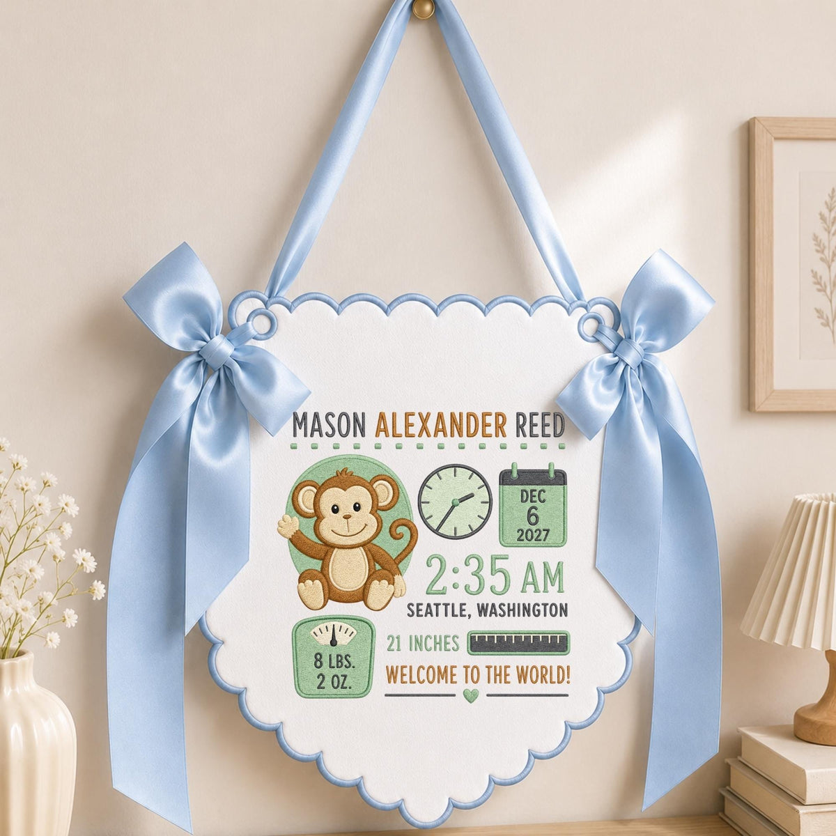 May include: A white scalloped wall hanging with light blue ribbon bows and trim. It features a brown monkey illustration, a clock, a calendar showing Dec 6 2027, and text: Mason Alexander Reed, 2:35 AM, Seattle, Washington, 8 lbs. 2 oz., 21 inches.