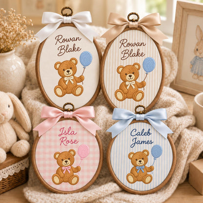May include: Four oval wooden embroidery hoops featuring embroidered brown teddy bears holding balloons. Two hoops display the name Rowan Blake, one displays Isla Rose, and one displays Caleb James. Each hoop is topped with a satin ribbon bow.
