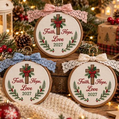 May include: Three circular wooden embroidery hoops featuring white fabric with embroidered brown crosses, green pine branches, red berries, and red bows. The text reads Faith, Hope, Love 2027. Each hoop is topped with a decorative lace bow in pink, blue, or cream.