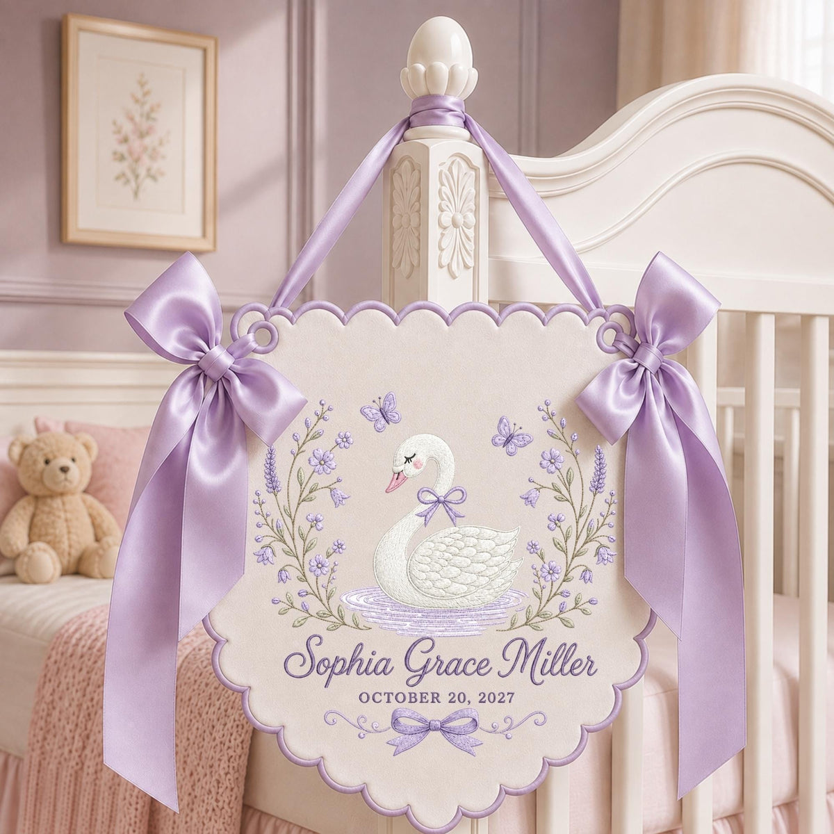 May include: A cream-colored scalloped wall hanging featuring an embroidered white swan with a purple bow, surrounded by purple flowers and butterflies. The text reads Sophia Grace Miller and OCTOBER 20, 2027, accented by two large lavender satin bows.