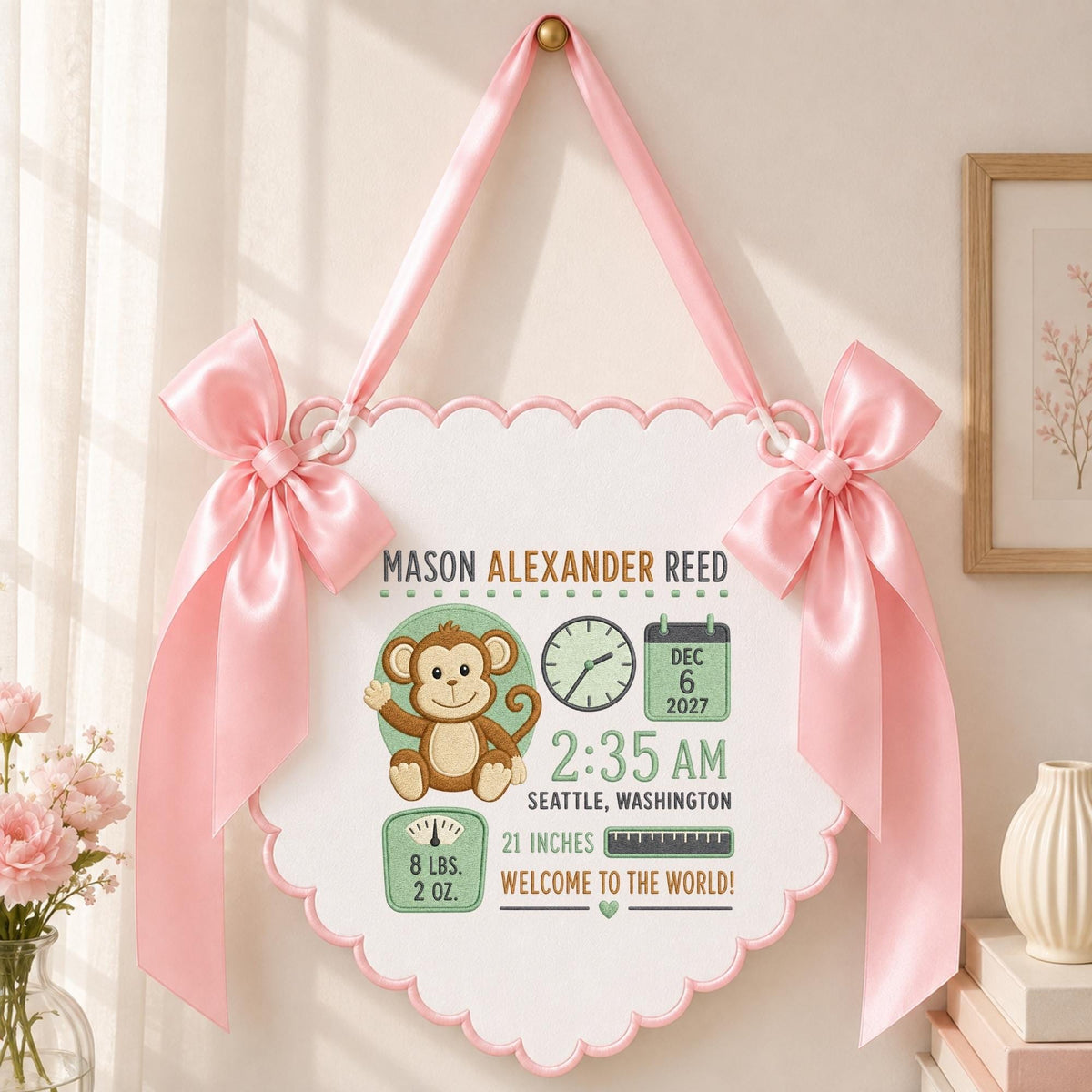 May include: A white scalloped wall hanging featuring a brown monkey illustration, a clock, a calendar showing Dec 6 2027, and text including Mason Alexander Reed, 2:35 AM, Seattle, Washington, 21 inches, and 8 lbs. 2 oz. with pink satin bows.
