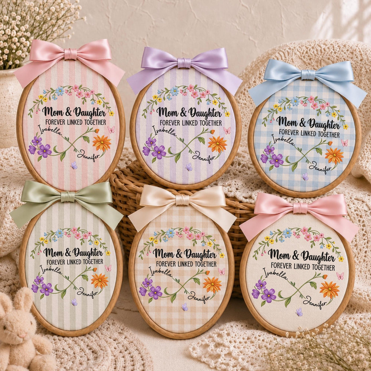 May include: Six oval embroidery hoops featuring fabric with various patterns and colors. Each hoop displays a floral wreath, an infinity symbol, and the text 'Mom &amp; Daughter FOREVER LINKED TOGETHER' with the names 'Isabella' and 'Jennifer' printed on them.