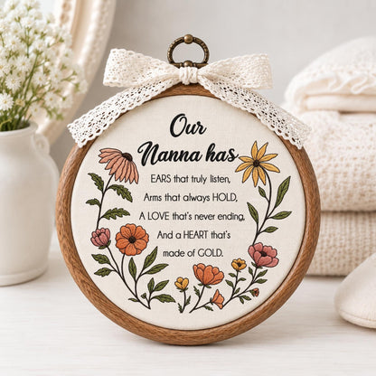 May include: A circular wooden embroidery hoop containing off-white fabric with floral embroidery and black text reading: Our Nanna has EARS that truly listen, Arms that always HOLD, A LOVE that's never ending, And a HEART that's made of GOLD. A lace bow sits on top.