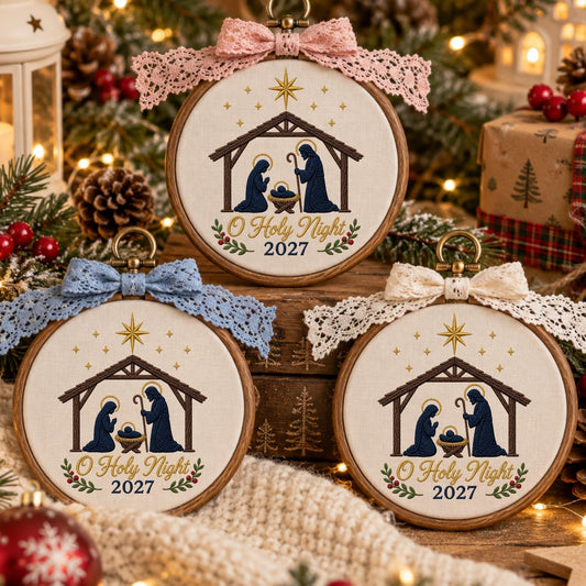 May include: Three circular wooden embroidery hoops featuring a nativity scene with a stable, figures, and a star. Each hoop is topped with a lace bow in pink, blue, or cream. The text O Holy Night 2027 is embroidered in brown on cream fabric.